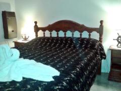 une chambre avec un lit avec une tête de lit en bois dans l'établissement Antawara, à Merlo