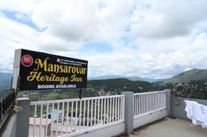 un cartello per un ristorante su un balcone di Mansarovar Heritage Inn ad Almora