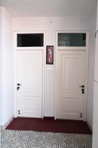 due porte bianche in una stanza con un tappeto rosso di Mansarovar Heritage Inn ad Almora