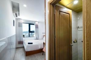 a small bedroom with a bed and a bathroom at Sóng Apartment - Seaside retreat in Da Nang +91 photos