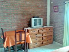 - une table avec une télévision au-dessus d'une commode dans l'établissement Antawara, à Merlo