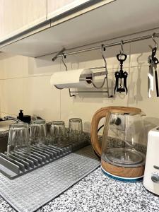 a kitchen counter with glasses on a stove at Moderna Suite GPT con piscina y cochera in San Miguel de Tucumán +48 photos