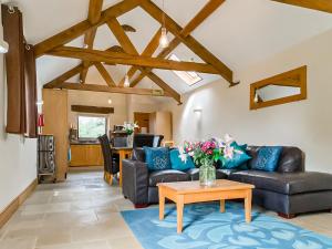 una sala de estar con un sofá y una mesa en Bramble Barn, en Tortworth