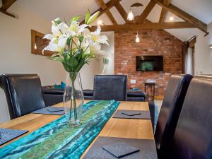 un jarrón de flores blancas sentado en una mesa en Bramble Barn, en Tortworth