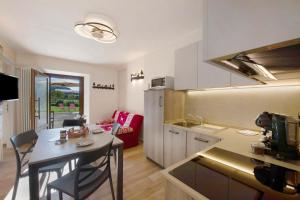 a kitchen and a living room with a table in a kitchen at Agriturismo La Grange in Pont-Saint-Martin