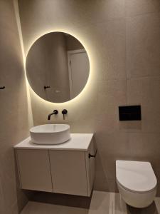 een badkamer met een wastafel en een spiegel bij Hypnos Residence Acropolis in Strovolos +26 foto's