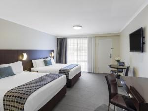 a hotel room with two beds and a desk and a television at Mercure Wagga Wagga in Wagga Wagga +52 photos