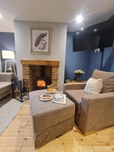a living room with a couch and a fireplace at Coachway Cottage in Ilkley