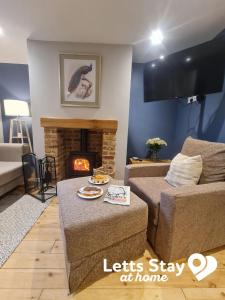a living room with a couch and a fireplace at Coachway Cottage in Ilkley