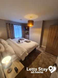 a bedroom with a bed and a window with a sink at Coachway Cottage in Ilkley