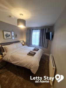 a bedroom with a bed with two towels on it at Coachway Cottage in Ilkley