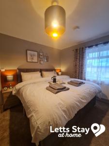 a bedroom with a large bed with two towels on it at Coachway Cottage in Ilkley +13 photos