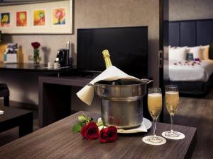 - une bouteille de champagne dans un seau sur une table avec deux verres dans l'établissement Mercure Santiago Centro, à Santiago