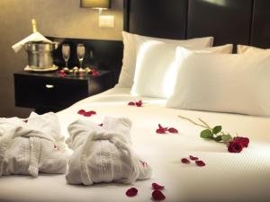 Una habitación de hotel con toallas y flores en una cama. en Mercure Santiago Centro, en Santiago 30 fotos más