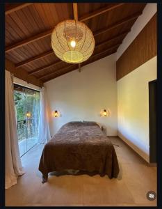 une chambre avec un lit et une grande fenêtre dans l'établissement Casa shizen, à Nova Friburgo