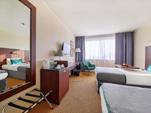 a hotel room with two beds and a mirror at Mercure Warszawa Airport in Warsaw +63 photos