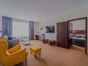 a living room with a yellow chair and a couch at Mercure Warszawa Airport in Warsaw