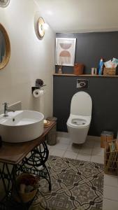 a bathroom with a white toilet and a sink at Une pause au milieu des bois in Foulayronnes