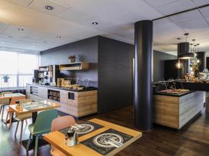 a kitchen and dining room with tables and chairs at Mercure Hotel Berlin Zentrum Superior in Berlin