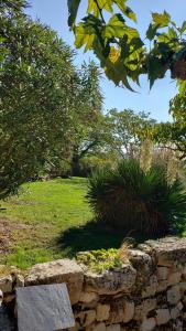 a stone wall with a bench in a garden at Une pause au milieu des bois in Foulayronnes +2 photos