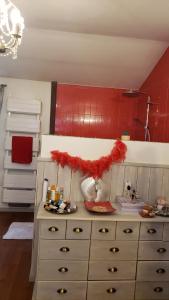 a dresser in a kitchen with a red wall at Une pause au milieu des bois in Foulayronnes