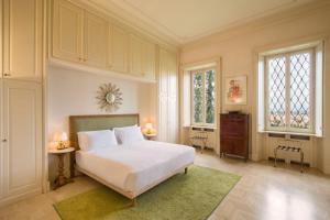 a bedroom with a bed and two tables and two windows at Villa del Cavaliere Berico in Vicenza +78 photos