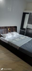 1 cama grande en una habitación con espejo en sahithya comfort homestay, en Bangalore