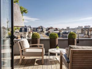 a balcony with chairs and a table and a view at Balthazar Hotel & Spa Rennes - MGallery Collection in Rennes