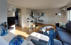 a living room with a blue couch and a table at 4 Bedroom Beautiful Home In Heberg in Grimsholmen