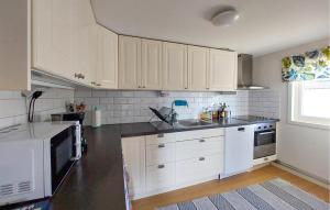 a kitchen with white cabinets and a black counter top at 4 Bedroom Beautiful Home In Heberg in Grimsholmen