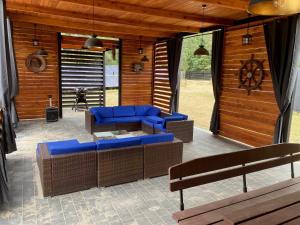 a patio with blue couches and chairs on a porch at domkibajka 