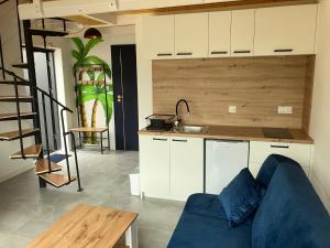 a living room with a blue couch and a kitchen at domkibajka 