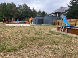 a playground with a blue slide in a yard at domkibajka  +2 photos