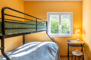 ein Schlafzimmer mit Etagenbett und Fenster in der Unterkunft Appartement N°1 - Piscine Partagée in Lagorce + 14 Fotos