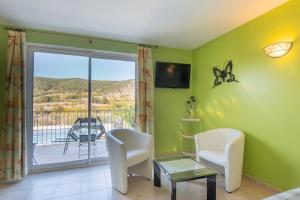 ein Wohnzimmer mit Blick auf einen Balkon in der Unterkunft Appartement N°1 - Piscine Partagée in Lagorce