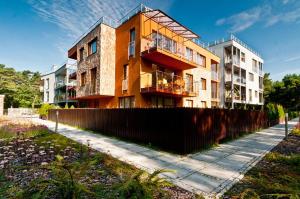 apartamentowiec z ogrodzeniem przed nim w obiekcie Willa 4 Żywioły BlueApart Jurata w Juracie