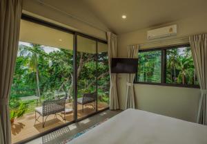 um quarto com uma cama e uma janela grande em Wok Tum Sunset Paradise Villa by Sea N' Rent em Haad Pleayleam mais 58 fotografias