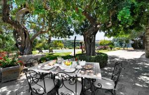 una mesa y sillas en un patio bajo un árbol en Pet Friendly Home In Ragusa, en Ragusa