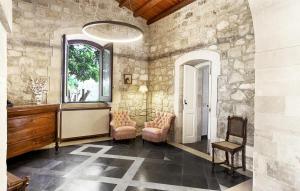 a room with stone walls and chairs and a window at Gorgeous Home In Ragusa in Ragusa