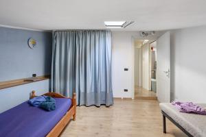 une chambre avec un lit violet et une fenêtre dans l'établissement Il Verziere Delle Rose, à Massa