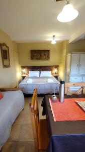 a hotel room with two beds and a table and chairs at Huerta de los Andes - Bed and Breakfast in Villa La Angostura