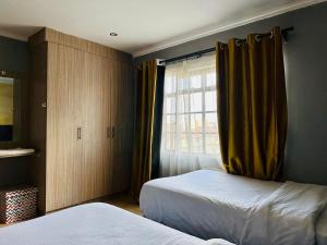 a bedroom with two beds and a window at Nersheys 2 bedroom Apartment near Junction Mall in Nairobi +22 photos