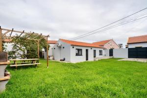 a yard with a picnic table and white buildings at Casa das Almas in Angra do Heroísmo