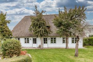 a white house with a thatched roof at Altes Schulmeisterhaus Wohnung 1 in Oevenum