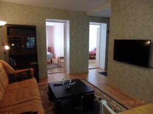 a living room with a couch and a tv at Torni Apartment in Kuressaare