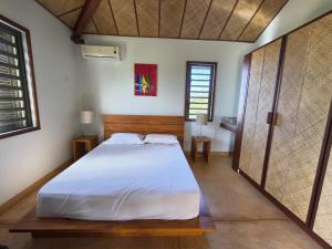 a bedroom with a large white bed in a room at Villa Ti Kabri, 500 m de la plage, Ile Rodrigues, Ile Maurice in Saint Francois