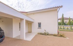 a white house with a car parked in front of it at Villa au coeur de Mézériat in Mézériat