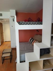 ein Zimmer mit zwei Etagenbetten und einem Tisch in der Unterkunft studio colibri in Saint-François