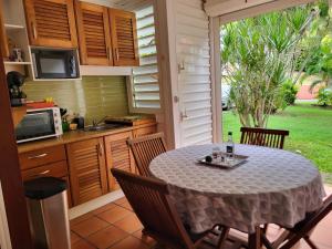 eine Küche mit einem Tisch und Stühlen in einer Küche in der Unterkunft studio colibri in Saint-François