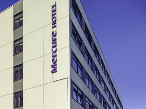 a building with a purple sign on the side of it at Mercure Hotel Koeln Belfortstrasse in Cologne